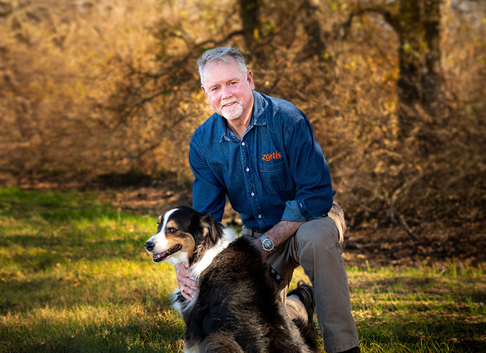 Dr. Mike McFarland with dog in field - Zoetis