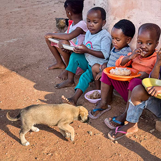 Children eating while dog wanders - Zoetis