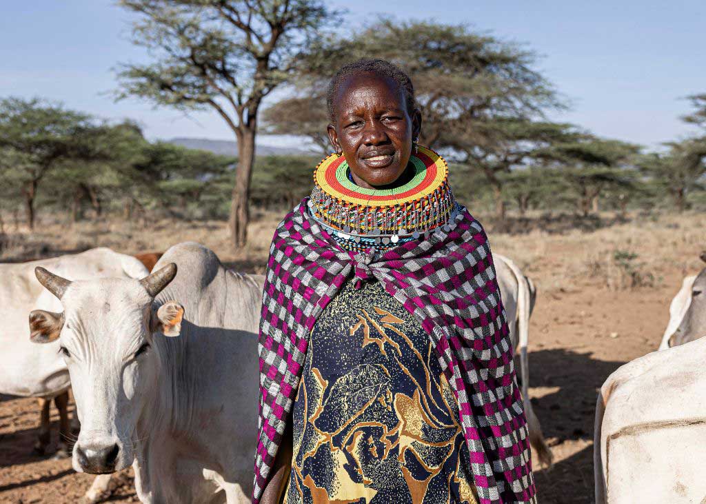 Village Agent standing next to a cow in Kenya - Zoetis 